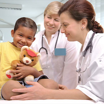 A little boy smiles and squeezes a teddy bear to his chest during his checkup. Links to Closely Held Business Stock A little boy smiles and squeezes a teddy bear to his chest during his checkup. Links to Closely Held Business Stock